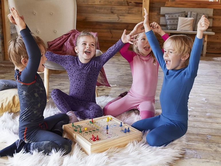 Kinder in Thermo-Unterwäsche spielen ein Brettspiel.