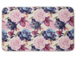 Ein weißer Teppich mit einem rosafarbenen und violetten Blumendesign.