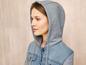 Eine Frau trägt einen grauen Hoodie mit einer Jeansjacke.