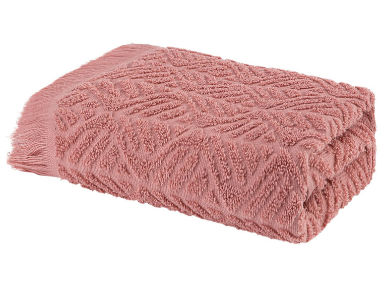 Ein rosa Handtuch mit einem strukturierten Muster und Fransen.
