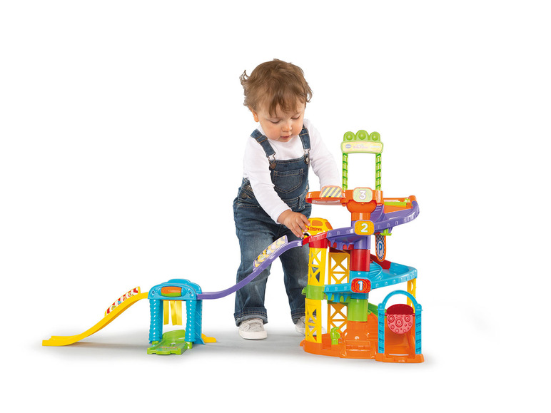 Ein Kind spielt mit einem VTech Baby's First Garage Spielset mit Autos und einer Waschanlage.