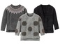 Drei Strickpullover: ein grauer mit skandinavischem Muster, ein grauer mit Punkten und ein schwarzer flauschiger Pullover.