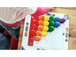 Ein Kind spielt mit dem Colorino mini steps Brettspiel mit bunten Punkten.