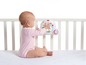 Ein Baby spielt mit einem Tiny Love Mobile über einem Kinderbett.