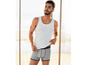 Mann trägt ein weißes Tanktop und graue Boxershorts.