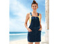 Eine Frau trägt ein Jeans-Overallkleid am Strand.