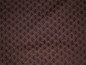 Brauner Stoff mit schwarzen Punkten.