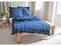 Blaue Bettwäsche mit Karomuster auf einem Holzbett.