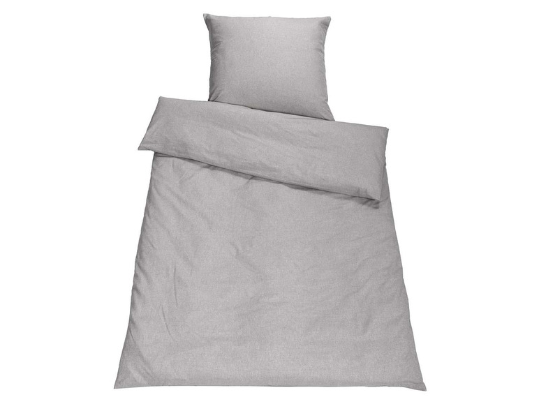 Ein graues Bettbezugset mit Bettdecke und Kissen.