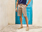Mann in beigen Shorts und Espadrilles.