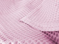 Ein rosa Handtuch mit Waffelstruktur.