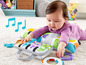 Ein Baby spielt mit einer Fisher-Price Spielmatte und einem Klavier.