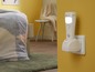 Eine weiße Nachtlampe mit Bewegungssensor, die in eine Steckdose gesteckt ist.