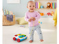 Ein Baby zieht einen Fisher-Price-Bauwagen mit bunten Bausteinen.