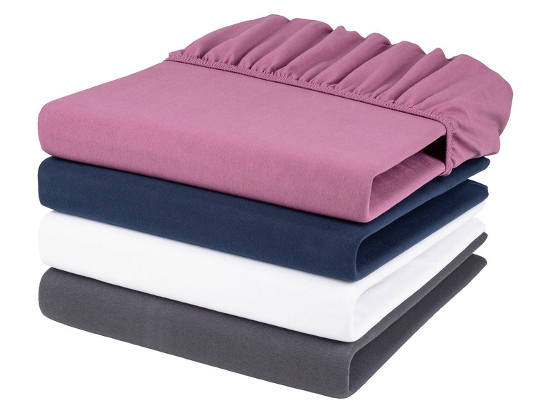 Ein Stapel Spannbettlaken in Rosa, Dunkelblau, Weiß und Grau.
