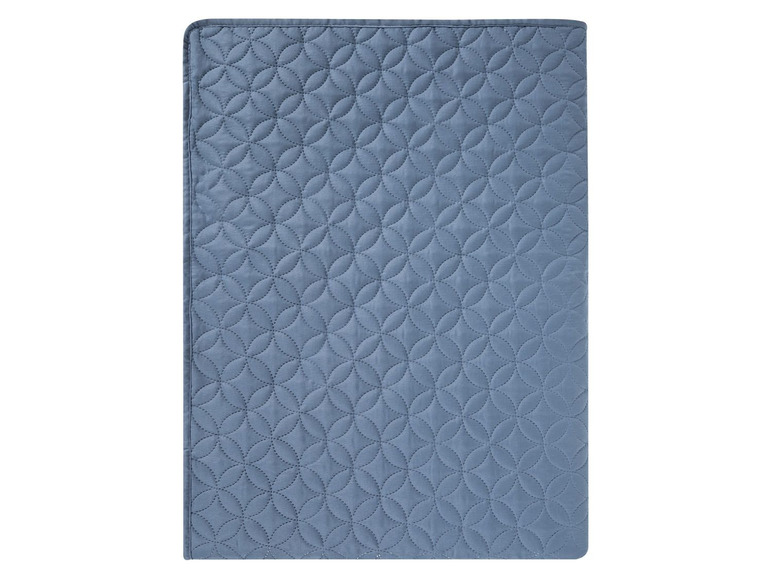 Ein blauer, gesteppter Bettbezug mit einem Kreis-Muster.