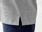 Ein graues Poloshirt mit seitlichen Schlitzen.