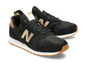 Schwarze New Balance Sneaker mit goldenen Akzenten.