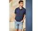 Mann in dunkelblauem Polo-Shirt und hellblauen Jeans-Shorts.