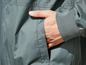Eine graue Windjacke mit einer Tasche