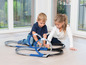 Zwei Kinder spielen mit einer Hot Wheels Rennbahn.