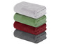 Ein Stapel aus vier Handtüchern in grau, rot, grün und weiß.