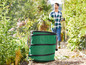 Ein grüner faltbarer Abfallbehälter im Garten.