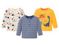Drei Baby-Shirts mit Streifen-, Dinosaurier- und Bergdesign.