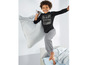 Ein Junge trägt einen schwarzen Pyjama mit der Aufschrift 'The Future Begins' und graue Schlafhose.