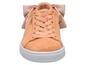 Beige Puma Suede Sneakers mit einer rosa Schleife.