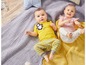 Zwei Babys in gestreiften und gepunkteten Klamotten auf einer Decke.