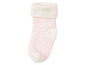 Ein Paar weiße Babysocken mit rosa Streifen.