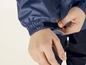 Eine blaue Regenjacke mit Klettverschluss am Ärmel.