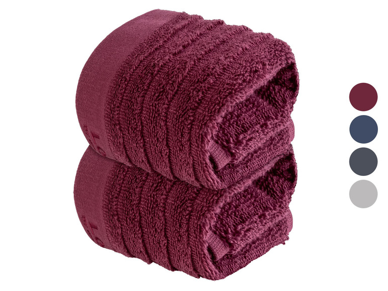 Zwei dunkelrote Handtücher, gefaltet.