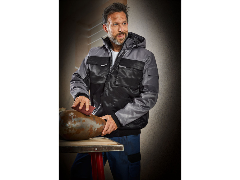 Ein Mann trägt eine schwarze und graue Arbeitsjacke