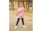 Ein Mädchen in einem rosa Hoodie und schwarzen Leggings hält einen Hula-Hoop-Reifen.