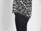 Schwarze Hose mit einer Bluse mit Zebra-Muster.