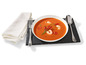 Tomatensuppe mit Garnelen, serviert mit Besteck.