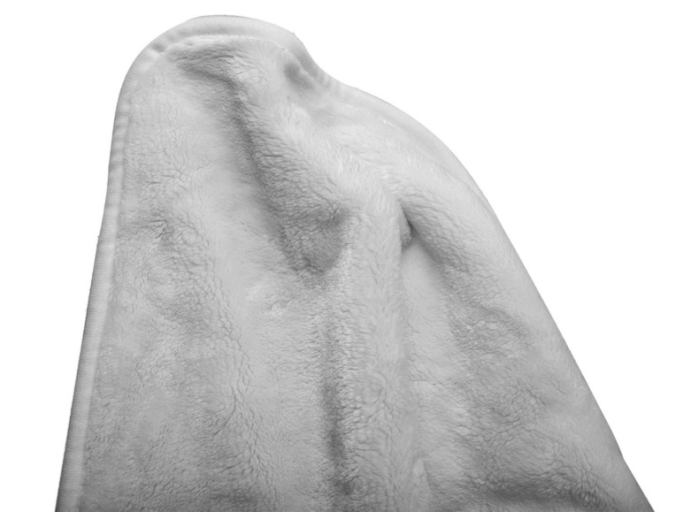 Eine weiche, weiße Decke mit flauschigem Muster.