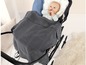 Ein Baby in einem schwarzen Kinderwagen mit einer grauen Strickdecke.