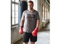 Mann in Sportkleidung mit Boxhandschuhen, bereit zum Training.