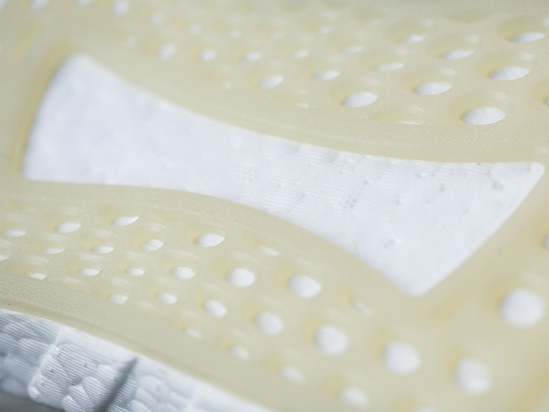 Nahaufnahme der weißen Sohle eines Adidas Sneakers mit Boost-Technologie.