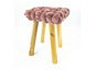 Rosa Hocker mit geflochtenem Sitz und Holzbeinen.