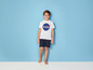 Ein Junge trägt ein weißes T-Shirt mit NASA-Logo und schwarze Shorts.