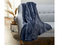 Eine dunkelblaue Fleece-Decke auf einem grauen Sofa.