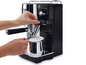 Schwarze De'Longhi Espressomaschine mit Milchaufschäumer.