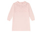 Ein rosa Strickkleid mit einem durchbrochenen Muster auf der Brust.