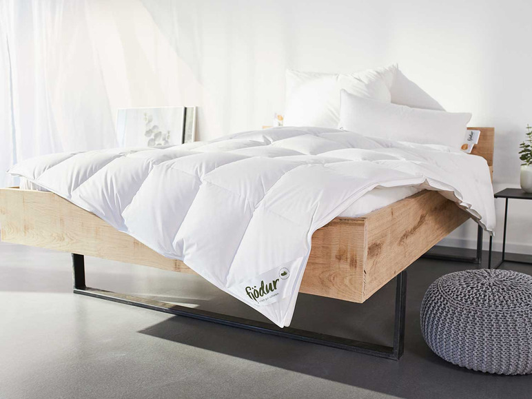 Ein weißes Fiodur-Bettdeckenset auf einem Holzbettgestell.