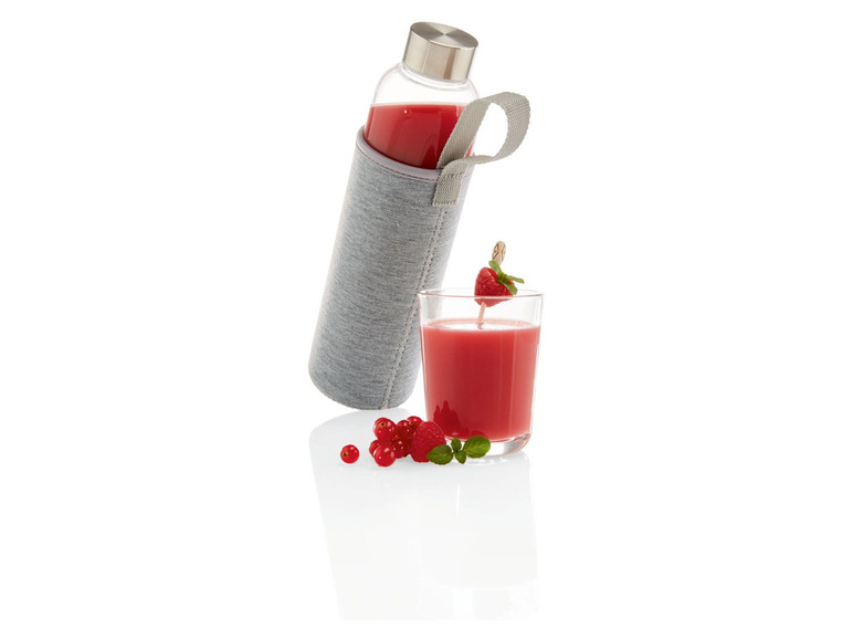 Eine Glaswasserflasche mit Schutzhülle und ein Glas Saft mit Himbeeren.