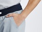 Ein Mann trägt graue Hosen mit einem schwarzen Gürtel.